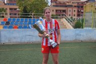 Blanca Plaza exhibiendo un trofeo y una medalla.