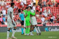 Los jugadores del Almería celebrando la victoria y Palencia mirando en segundo plano.