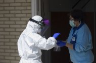 Un sanitario entrega las pruebas a otro, tras realizar una recogida de muestra desde el coche para detectar casos de coronavirus