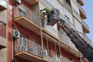 Los Bomberos de Almería trabajan en la ventana desde la que se han desprendido los cristales.