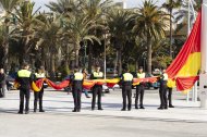 La Policía Portuaria sujetando la bandera de España antes de izarla