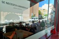 Cartel de 'Se busca camarero' en un bar con terraza de Almería.
