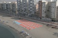 Casi 50 toallas gigantes dibujan un aparcamiento de 1.500 metros cuadrados en El Zapillo.