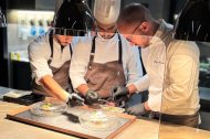 El chef Alfio Nicolosi, a la derecha de la imagen, durante la preparación de un plato.
