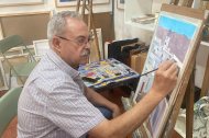 El pintor José Mario Sarabia pintando una de sus obras en su estudio.