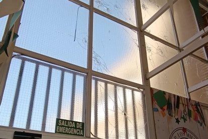 Hall del colegio Los Millares, con los cristales rotos, tras el lanzamiento de piedras