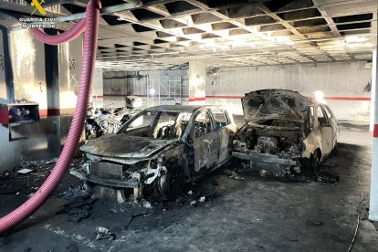 Coches calcinados en el garaje incendiado.