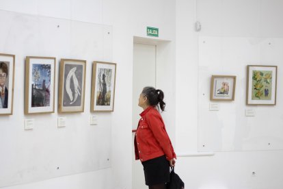 Una visitante recorre la exposición ‘Relatos Cinematográficos’ de la Asociación Profesional de Ilustradores de Almería en la Biblioteca Villaespesa.