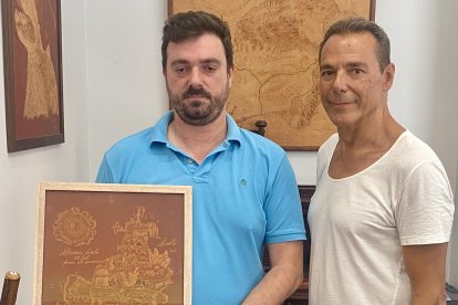 José Luis Ruíz junto al periodista Antonio Hermosa en su tienda de Curtidos Ruíz, rodeado de algunos bajo relieves realizados a manos sobre cuero.