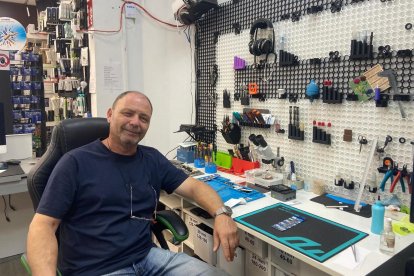 Iulian Marín sentado junto a su mesa de trabajo, en su tienda 'Todo tiene arreglo'.