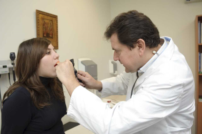 Un médico de familia examina a una joven paciente.