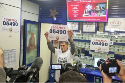 El gerente posa ante los medios con el cartel del número premiado.