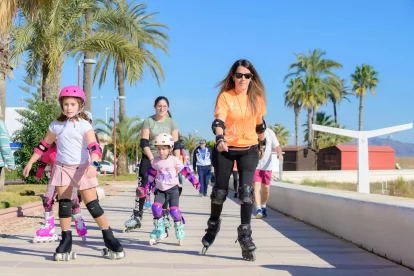 Una familia pasea en patines por el Paseo Marítimo veratense.