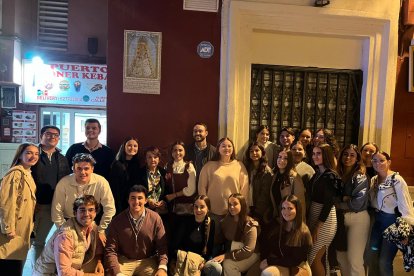 Foto de familia del grupo joven del Rocío con doña Rosa López bajo el azulejo de la Virgen del Rocío.