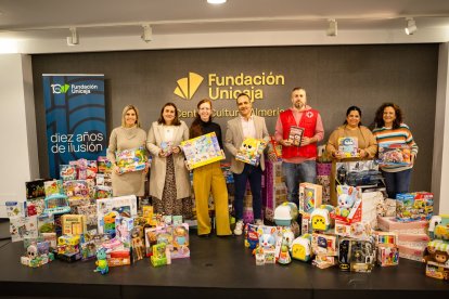 Los responsables de la donación rodeados de una parte de los regalos.