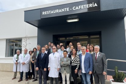 Las autoridades posan junto al personal del hospital frente a la nueva fachada de la cafetería.