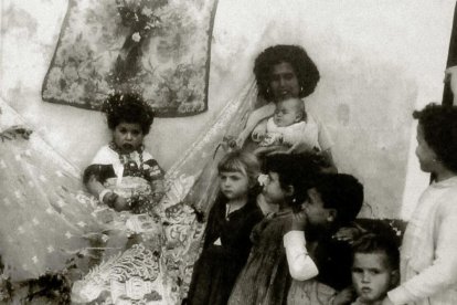 Niña vestida de maya en La Chanca, en una imagen de Pérez Siquier. La rodea su madre y una cohorte de niñas.