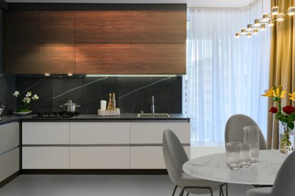 Cocina moderna y elegante con frentes porcelánicos en mármol veteado negro y muebles gola push, en madera.