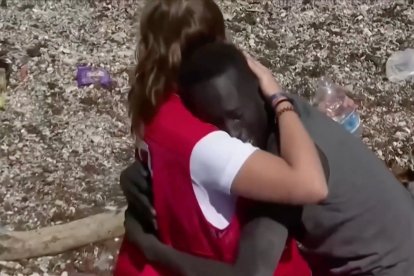 El joven senegalés Abdou, abrazado a Luna, una joven voluntaria de la Cruz Roja, a su llegada a la playa del Tarajal en Ceuta.