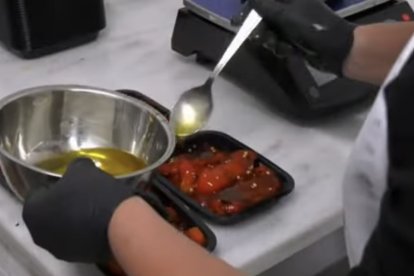 Pimientos 'El Leñero' asados a la leña y siendo rociados con aceite