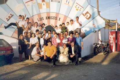 En su décimo Aniversario socios y camareros junto a la portada de la caseta.