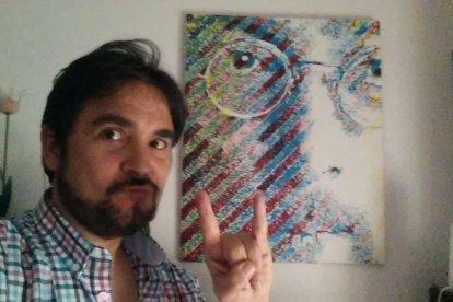 Adolfo Iglesias junto a una imagen de Lennon.