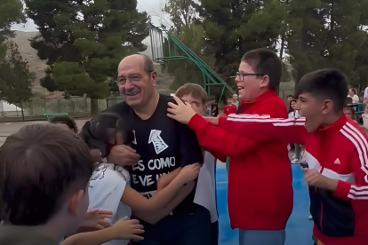 Alumnos y compañeros despiden en un largo pasillo por el patio a Julián el día de su despedida.