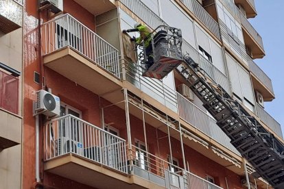 Los Bomberos de Almería trabajan en la ventana desde la que se han desprendido los cristales.