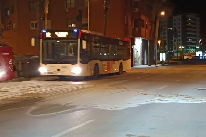 Un autobús del transporte público urbano de la capital pasando a baja velocidad sobre la acumulación de arena.