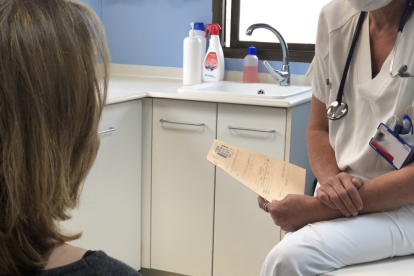 Un médico en su consulta con una paciente.