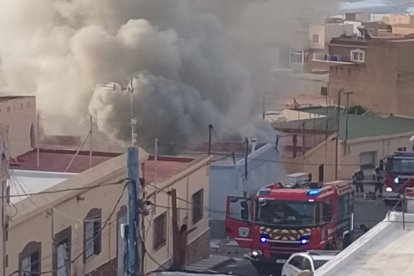 Bomberos actuando en la vivienda, todavía en llamas, de la calle Júpiter, en la pedanía de Puente del Río, en Adra.