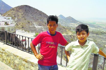 Dos niños de Mojácar, la mañana del viernes 24 de julio de 2009, con el fuego que asoló el pueblo recién apagado a sus espaldas, en el mirador de la calle París.