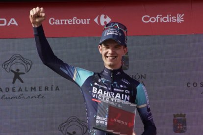 El ganador Jakob Omrzel, del equipo Bahrain, en el podio de Calar Alto con el logo de Costa de Almería detrás.