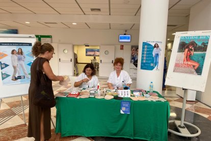 Montse Cabrera y una compañera en la mesa de información del paciente ostomizado.