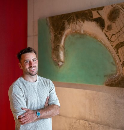 Álvaro Varela (Litoris Pictor), junto a su obra de la Playa de Genoveses, recién instalada en la sede de Cajamar.