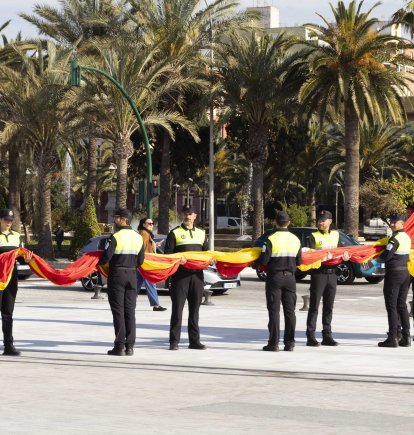La Policía Portuaria sujetando la bandera de España antes de izarla