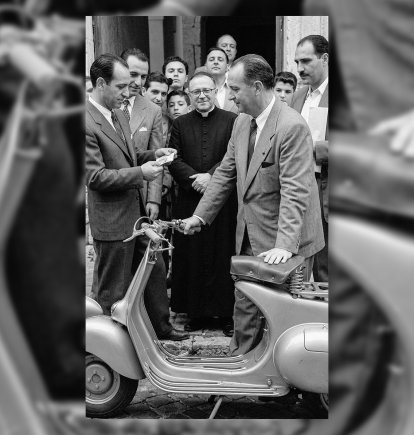 El juez municipal Mariano Fernández Ulibarri, recibiendo la Vespa que le había tocado en la tómbola ante el numeroso público congregado en la puerta del obispado. 1954.