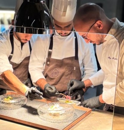 El chef Alfio Nicolosi, a la derecha de la imagen, durante la preparación de un plato.
