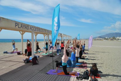 Asistentes a 'Tus playas de invierno' practicando yoga en Vera.