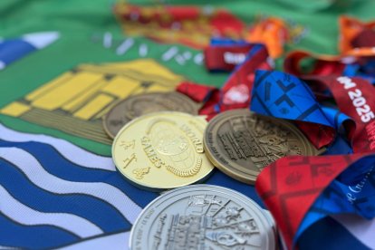 Medallas de los Juegos Mundiales de Policías y Bomberos sobre la bandera de El Ejido.