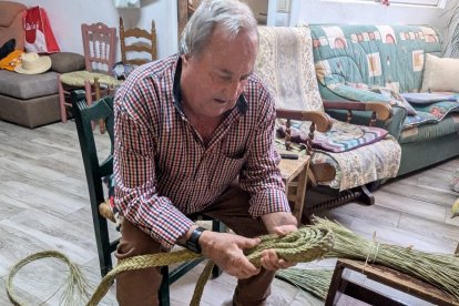 Manuel ensimismado haciendo trenza de esparto.