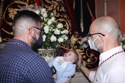El padre y el tío de Juan pasándolo bajo el manto de la Virgen de la Merced.