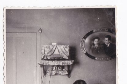 Mujer cosiendo en casa junto a su hijo y la radio, el gran entretenimiento en las casas en los 50 en Almería (Foto: Colección Museos de Terque).