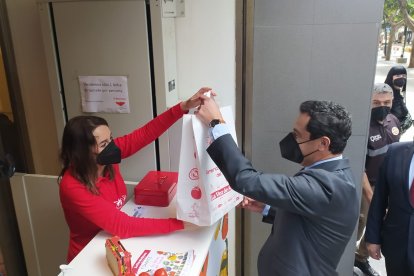 Juanma Moreno, presidente de la Junta de Andalucía, adquiere su bolsa de tomate solidario.
