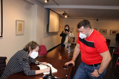 Contemplando la firma de su libro.