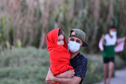 Un joven con un niño en brazos.
