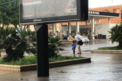 Con paraguas y pantalón corto.