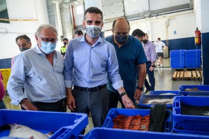 El alcalde muestra con orgullo los productos del mar.