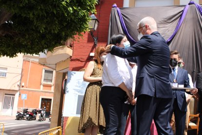 El alcalde impone la Medalla a la concejala.