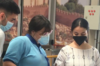 Sanitaria atendiendo a una chica para su vacunación.